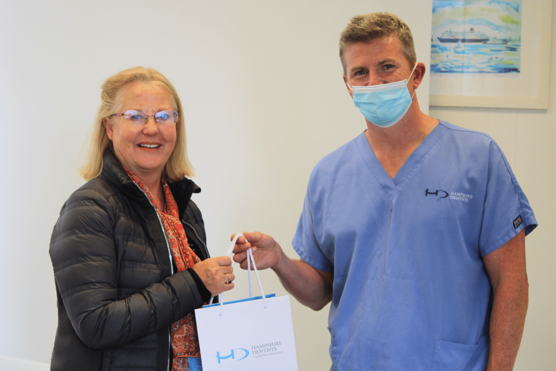 Teeth Whitening - Hampshire Dentists Pain Free Dentist in Southampton Dr Robin Hanna handing patient Hampshire Dentists gift bag with teeth whitening supplies