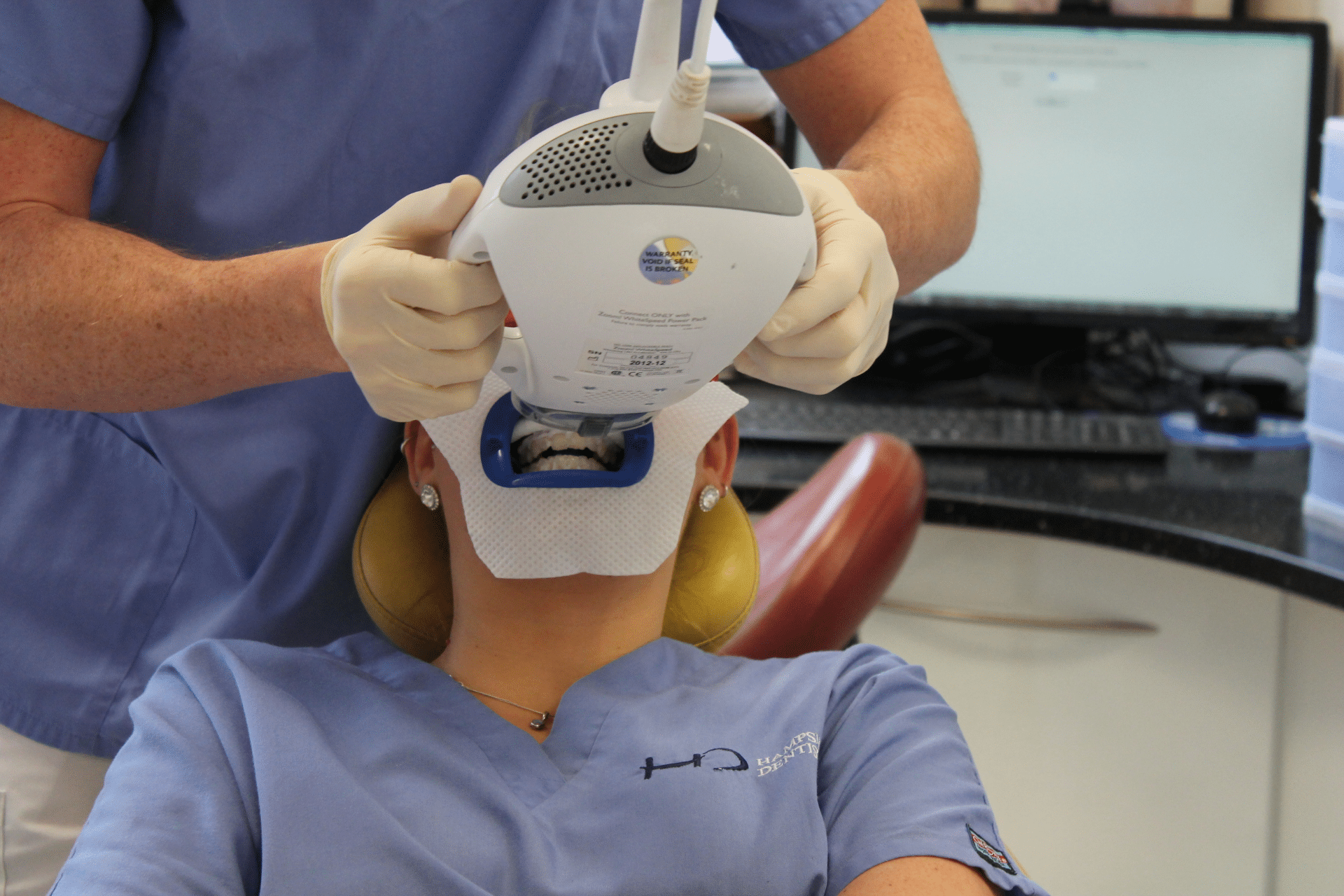 Teeth Whitening - Hampshire Dentists Pain Free Dentist in Southampton Dr Robin using light to activate power teeth whitening gel applied to patients prepared teeth