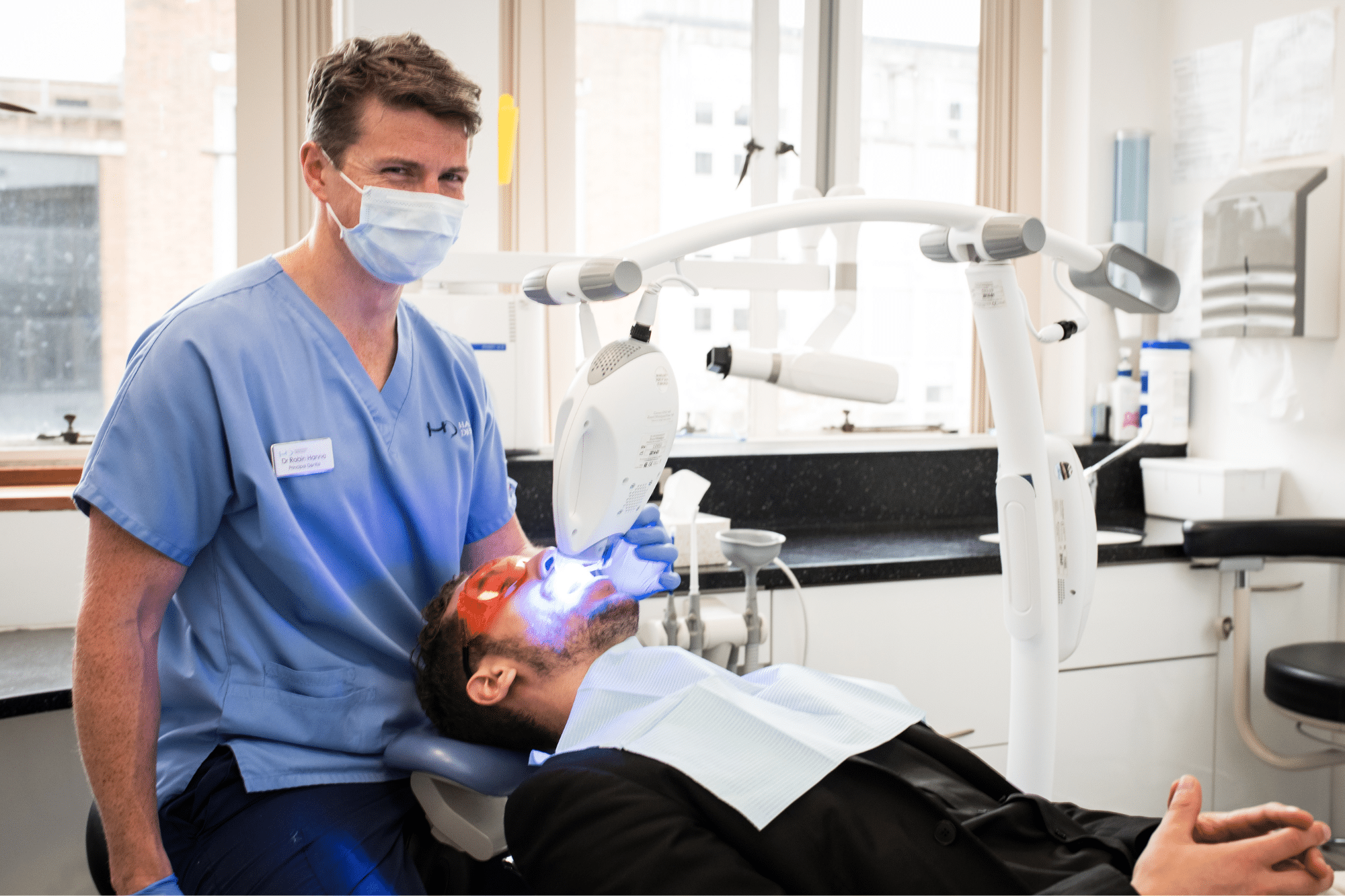 Teeth Whitening - Hampshire Dentists Pain Free Dentist in Southampton Dr Robin Hanna completing light activated power teeth whitening treatment on patient lying back in the dental chair