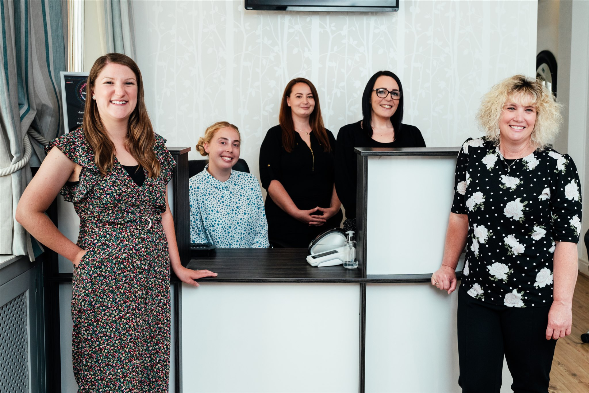 Hampshire dentists reception team standing around reception area