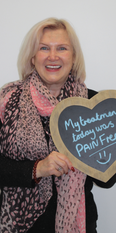 Patient Photos - Hampshire Dentists Pain Free Dentist in Southampton Patient at Hampshire Dentists, holding a sign saying " My treatment today was pain free " emphasising pain-free dental care.