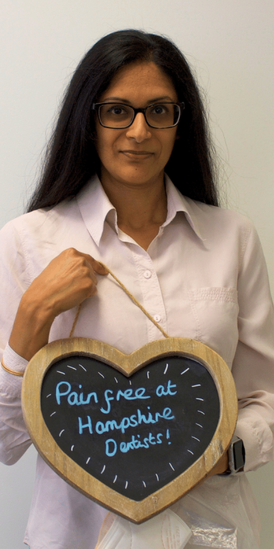 Patient Photos - Hampshire Dentists Pain Free Dentist in Southampton Patient at Hampshire Dentists, holding a sign saying "Pain free at Hampshire Dentists" emphasising pain-free dental care.